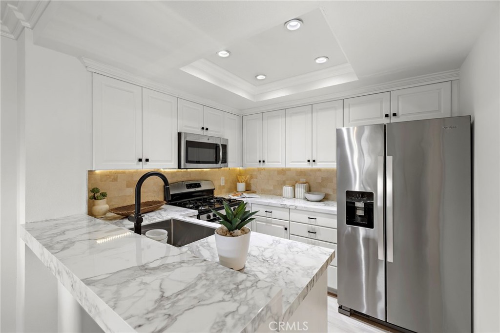 168 23rd Street, Unit D Costa Mesa, CA 92627 - Photo 11 of 26 a kitchen with stainless steel appliances granite countertop a refrigerator a stove top oven a sink and dishwasher