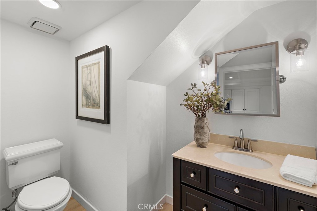 168 23rd Street, Unit D Costa Mesa, CA 92627 - Photo 12 of 26 a bathroom with a toilet a sink and mirror