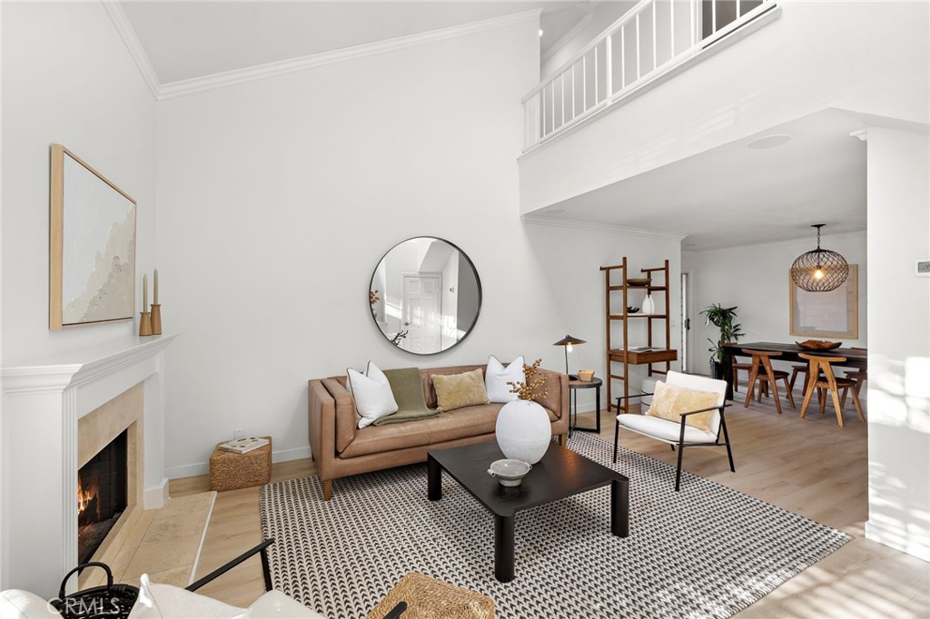 168 23rd Street, Unit D Costa Mesa, CA 92627 - Photo 2 of 26 a living room with furniture a fireplace and a dining table with wooden floor