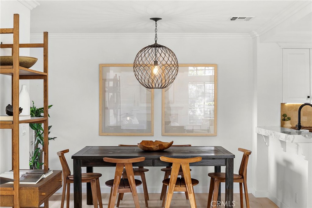 168 23rd Street, Unit D Costa Mesa, CA 92627 - Photo 6 of 26 a view of a dining room with furniture wooden floor and chandelier