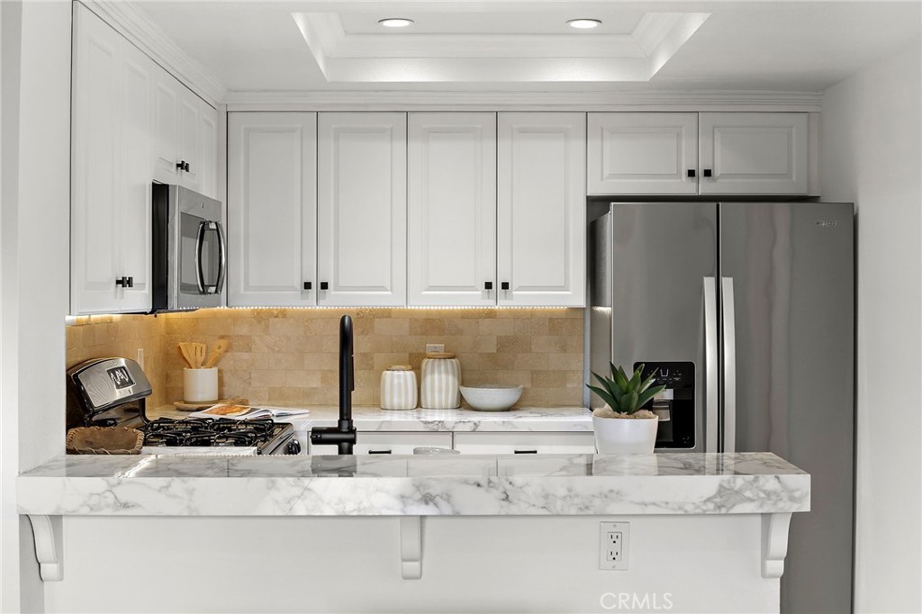 168 23rd Street, Unit D Costa Mesa, CA 92627 - Photo 8 of 26 a kitchen with kitchen island a counter top space and cabinets