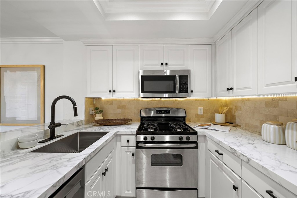 168 23rd Street, Unit D Costa Mesa, CA 92627 - Photo 10 of 26 a kitchen with granite countertop white cabinets and stainless steel appliances