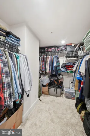 a view of walk in closet with clothes and shoes