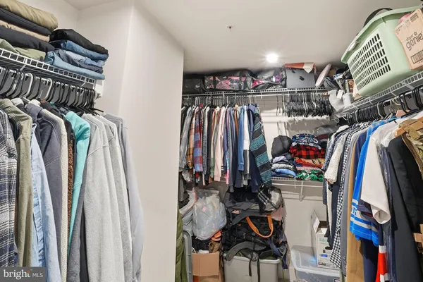 a view of walk in closet with clothes and shoes
