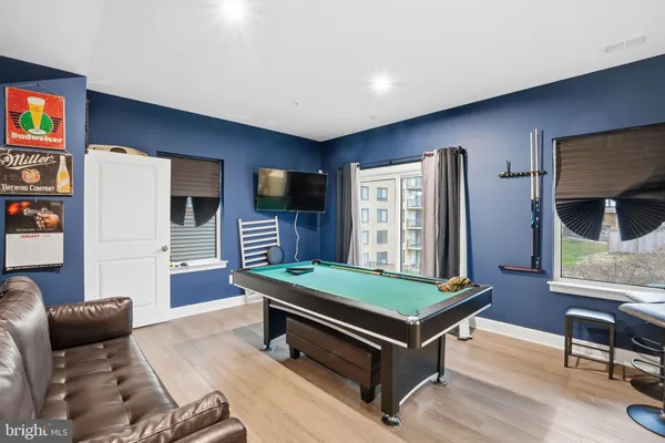 a room with furniture pool table and flat screen tv