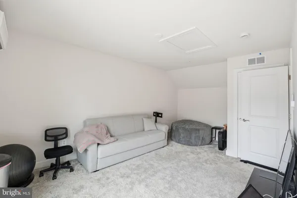 a living room with furniture and a refrigerator