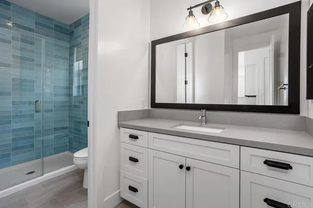a bathroom with a granite countertop sink a toilet and a mirror