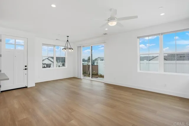 a view of an empty room with window and wooden floor