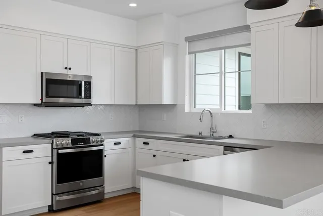 a kitchen with appliances a sink and a microwave