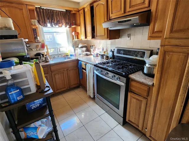 a kitchen with granite countertop a stove top oven a sink and dishwasher