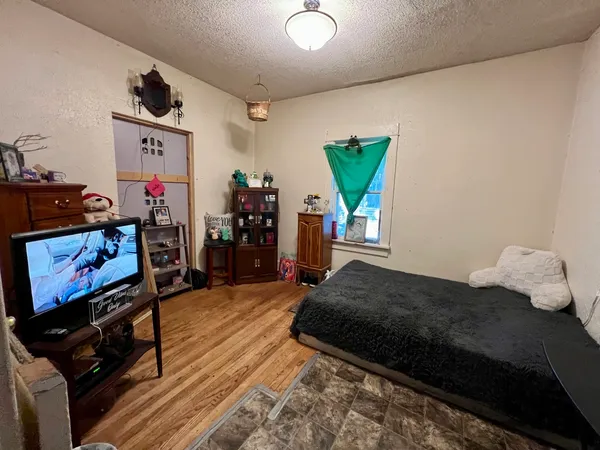 a bedroom with bed and a flat screen tv
