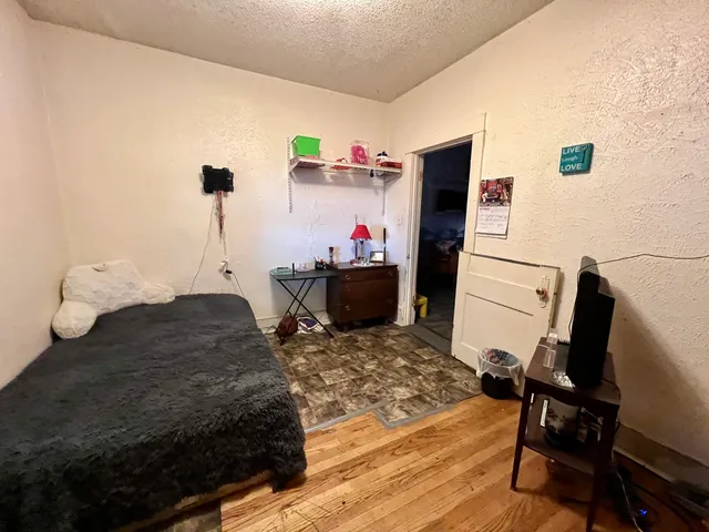 a bedroom with a bed and wooden floor