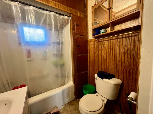 a bathroom with a toilet and a shower curtain