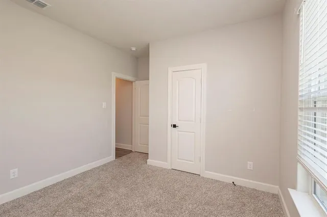 an empty room with wooden floor ceiling fan and windows