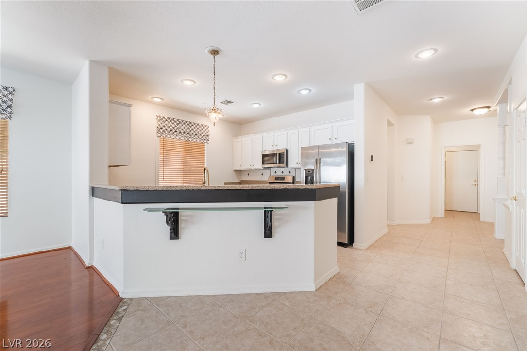 5389 Progresso Street Las Vegas, NV 89135 - Photo 13 of 41 A well-appointed kitchen features a practical island, recessed lighting, and modern stainless steel appliances.