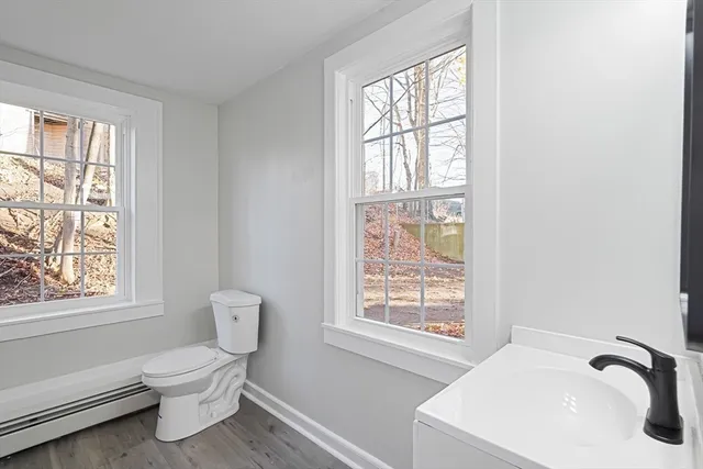 a bathroom with a toilet a sink and a window
