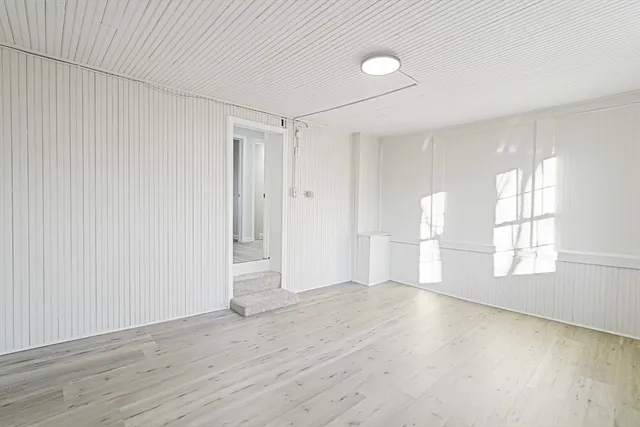 wooden floor in an empty room with a window
