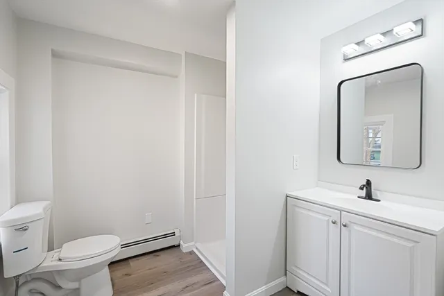 a bathroom with a toilet a sink and mirror