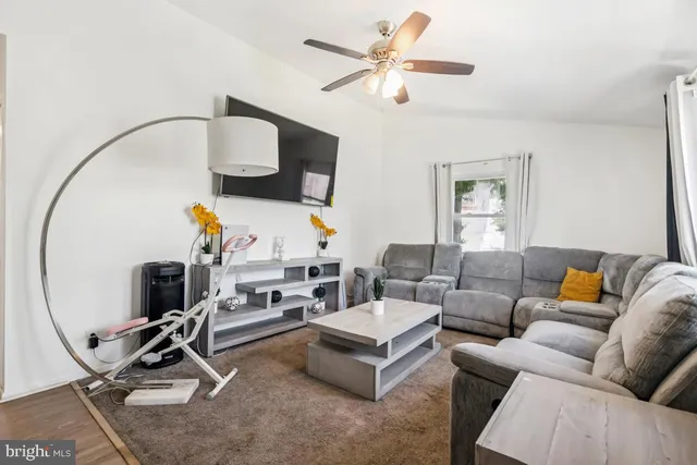 a living room with furniture a flat screen tv and a window