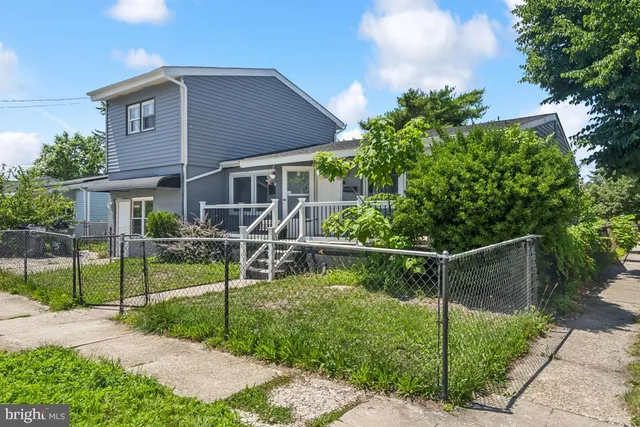 a view of house with a yard and sitting area