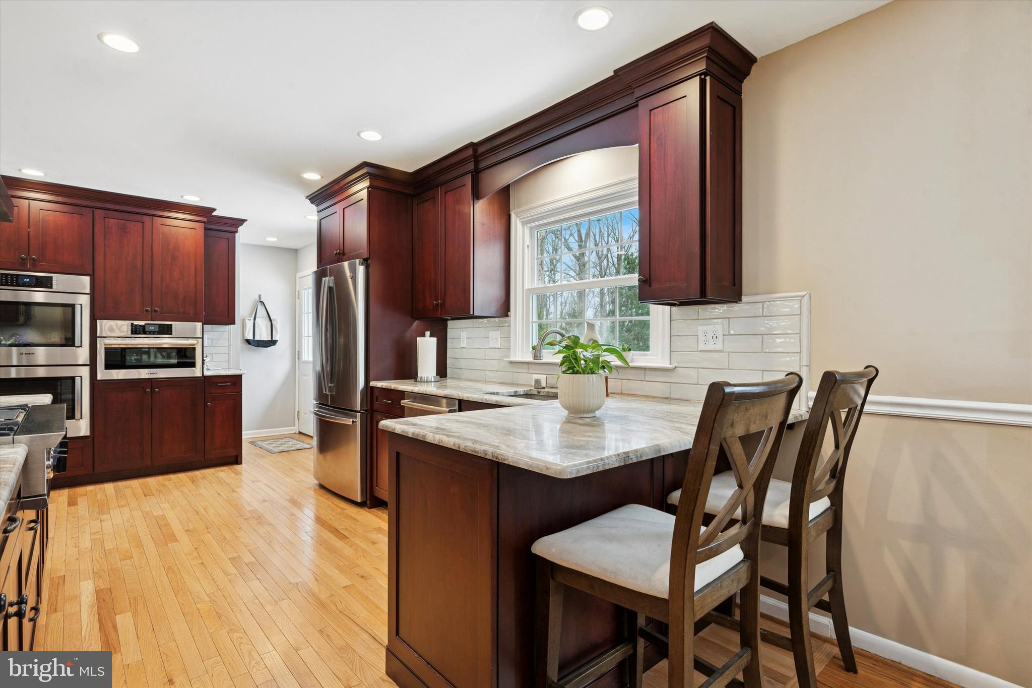 1052 West Valley Hill Road Malvern, PA 19355 - Photo 11 of 25 a kitchen with a table chairs refrigerator and microwave