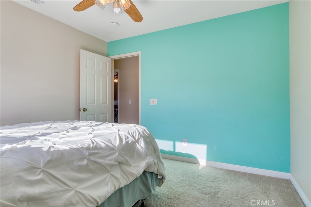 20885 Bakal Drive Riverside, CA 92508 - Photo 23 of 47 a bedroom with a bed and a chandelier