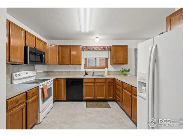 a open kitchen with a refrigerator and a sink