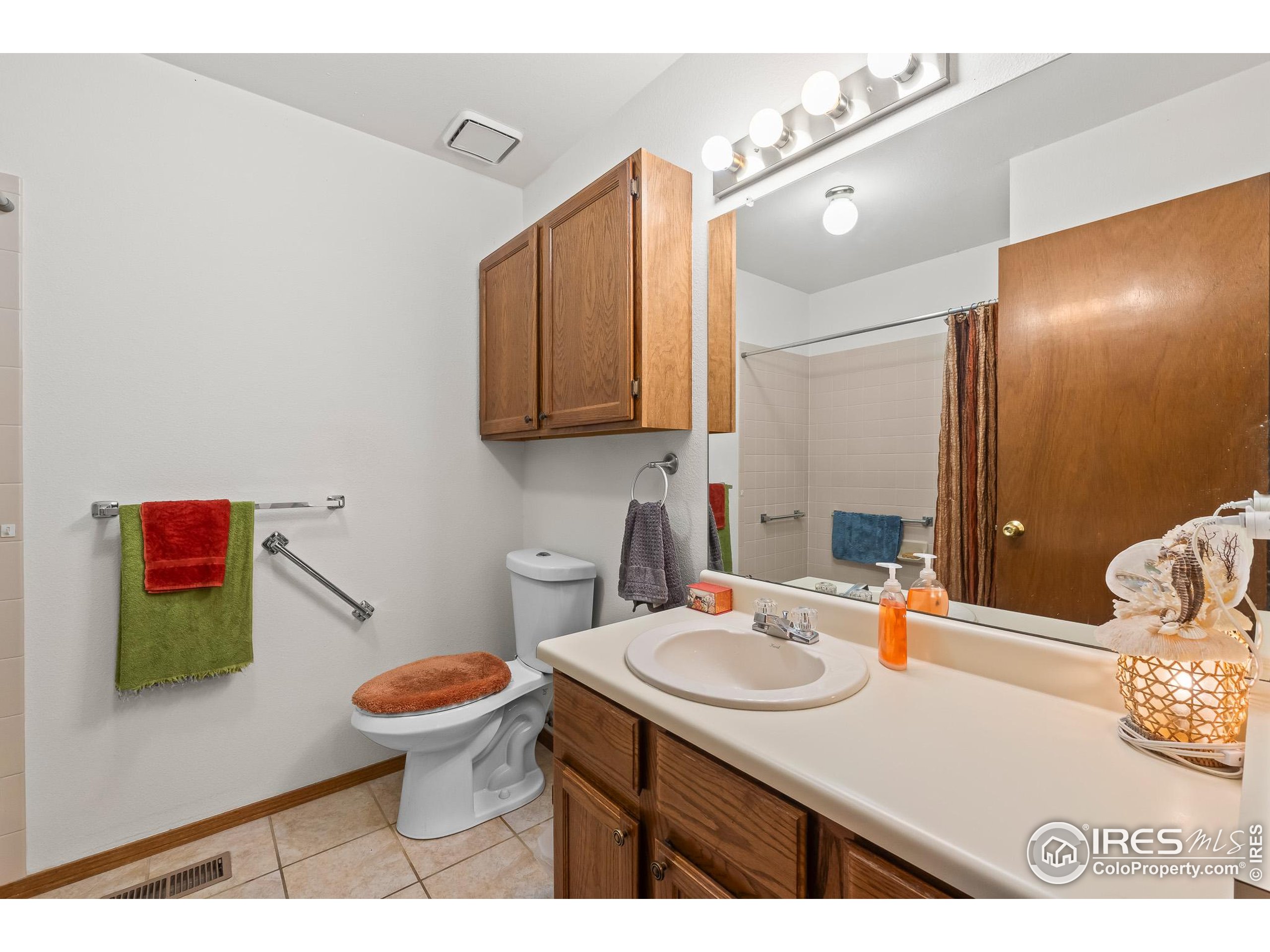 1100 South Taft Avenue, Unit 46 Loveland, CO 80537 - Photo 26 of 31 a bathroom with a sink a toilet and mirror