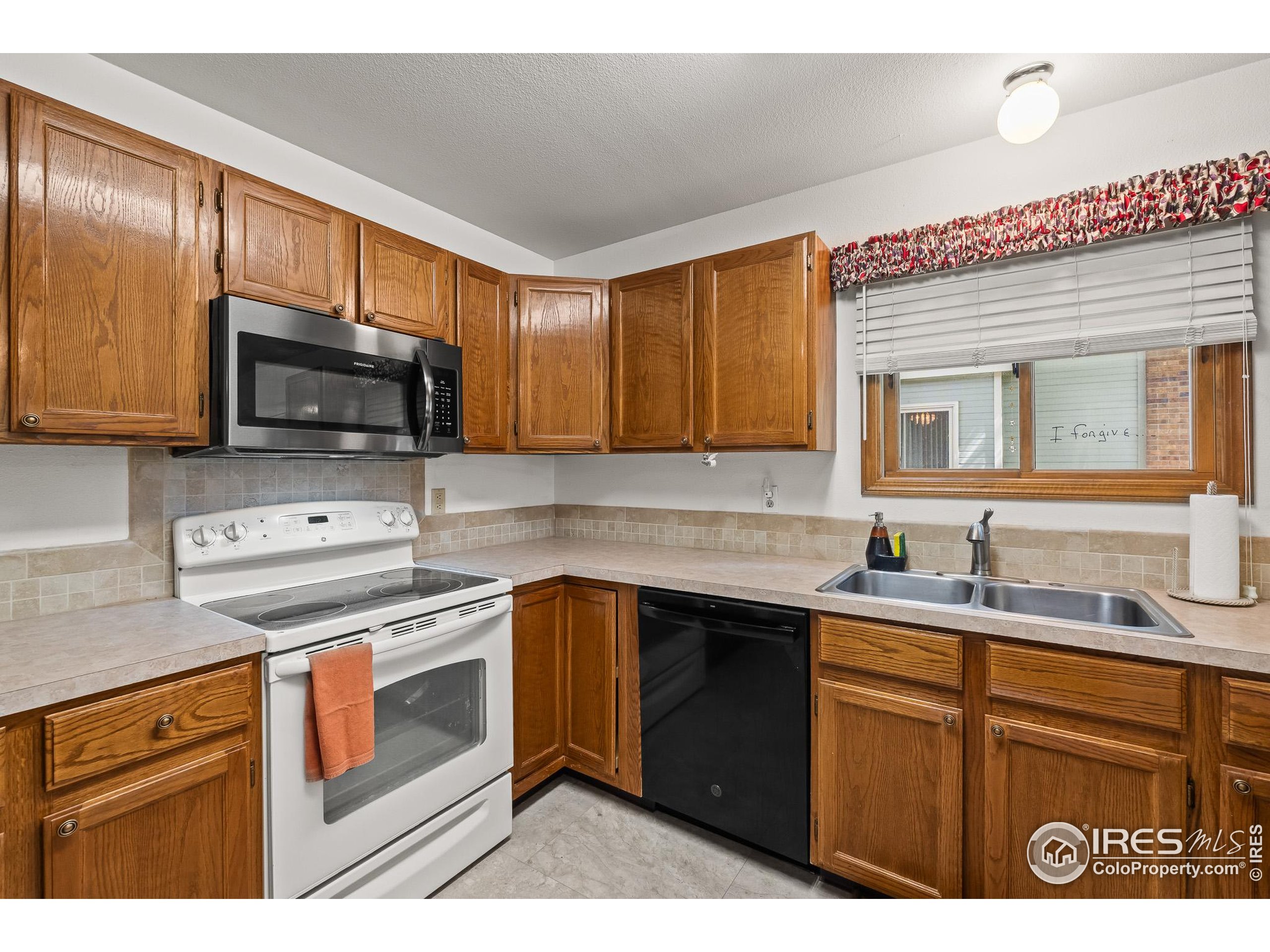 1100 South Taft Avenue, Unit 46 Loveland, CO 80537 - Photo 9 of 31 a kitchen with a sink stove top oven and cabinets