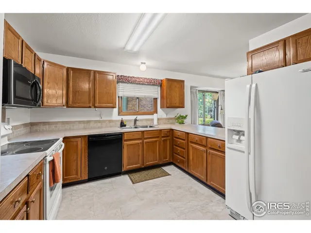 a kitchen with stainless steel appliances granite countertop a refrigerator a stove top oven a sink and dishwasher
