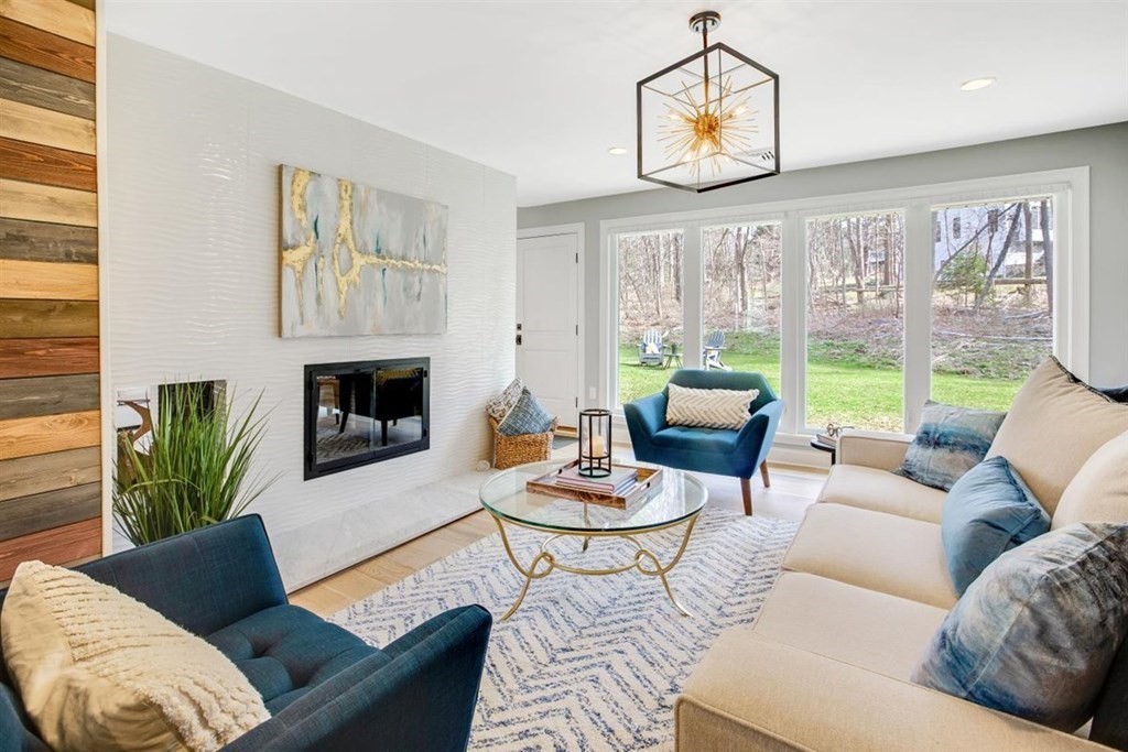 2 West Knoll Road Andover, MA 01810 - Photo 12 of 29 a living room with furniture a fireplace and a floor to ceiling window