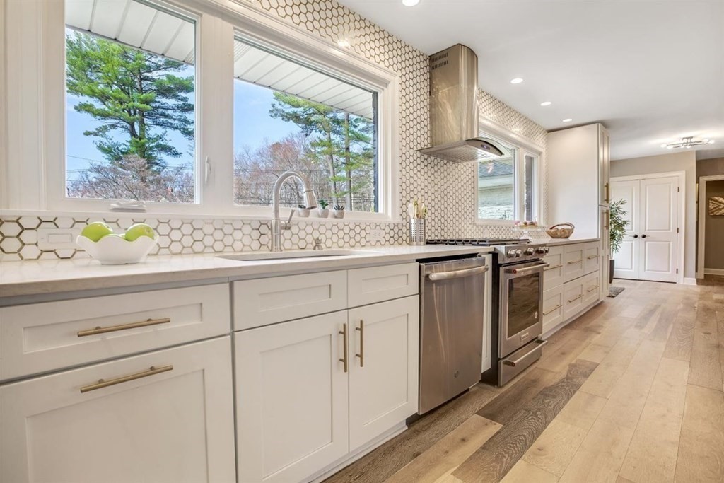2 West Knoll Road Andover, MA 01810 - Photo 3 of 29 a kitchen with stainless steel appliances white cabinets and wooden floors