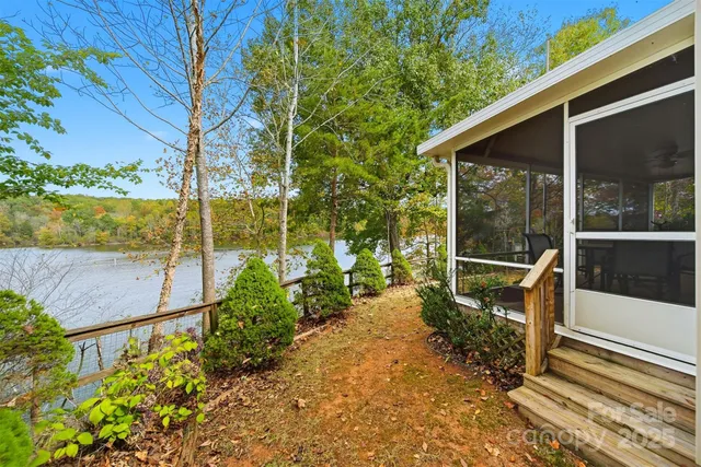 a view of a chair with a floor to ceiling window next to a yard