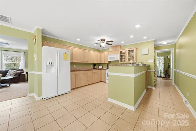 a view of a kitchen with furniture and refrigerator