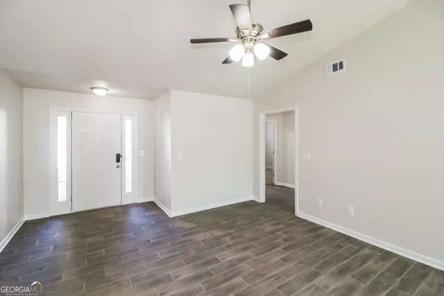 a view of an empty room with wooden floor