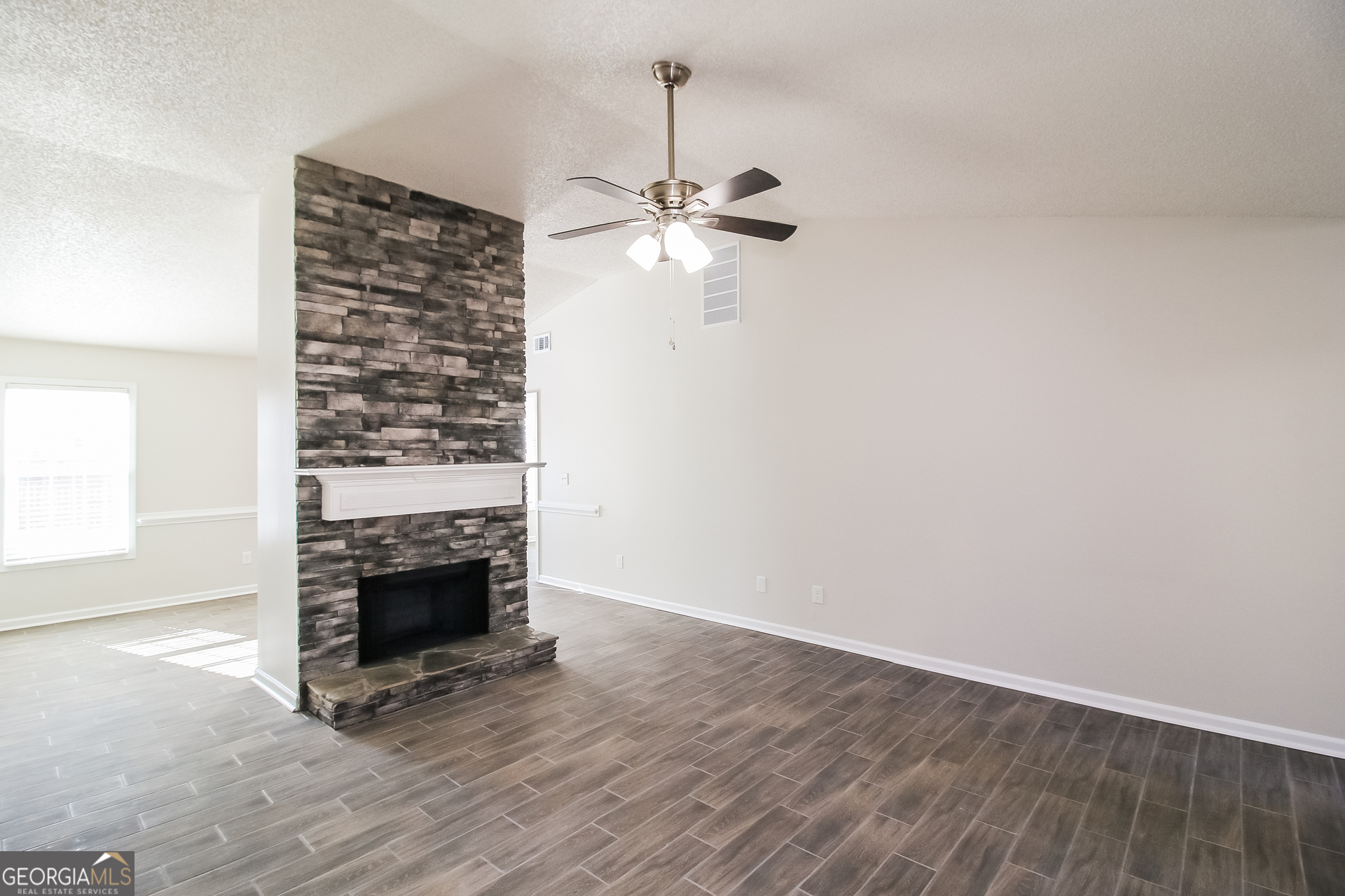 10381 Commons Crossing Jonesboro, GA 30238 - Photo 4 of 17 a view of empty room with wooden floor and fan
