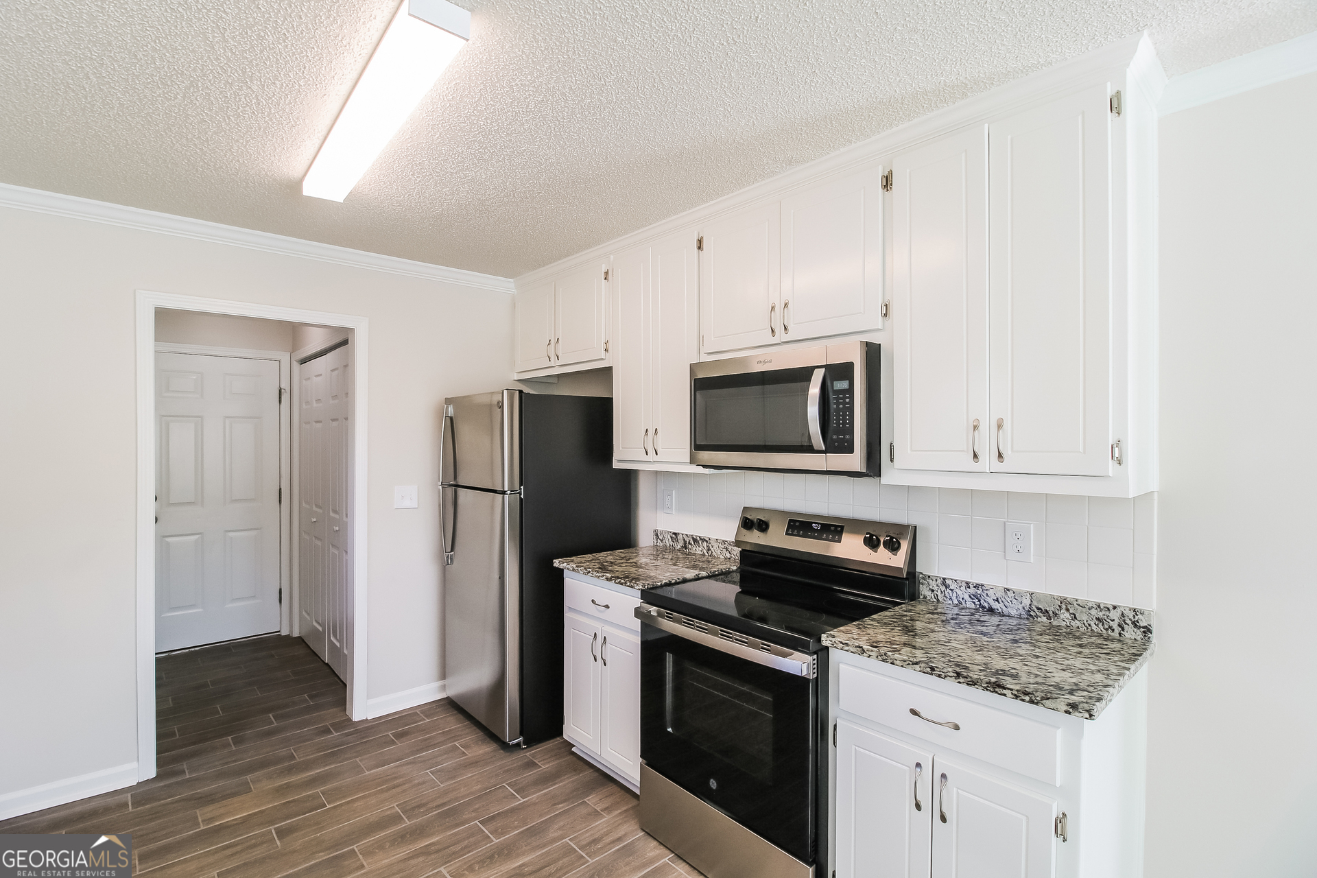 10381 Commons Crossing Jonesboro, GA 30238 - Photo 6 of 17 a kitchen with stainless steel appliances granite countertop a stove a refrigerator and a microwave