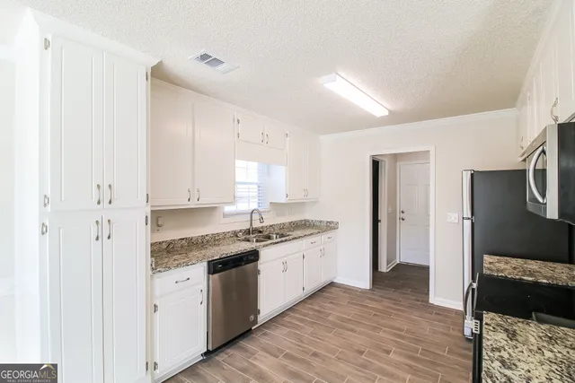 a kitchen with a sink stove and cabinets