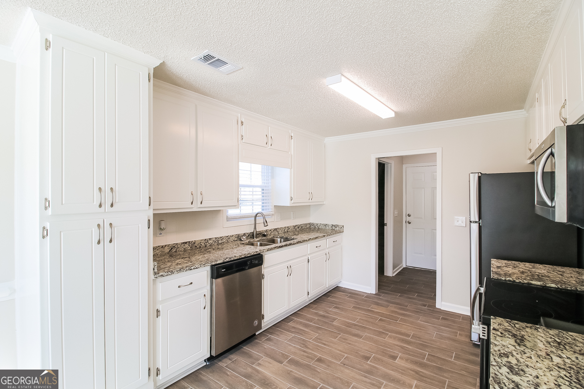 10381 Commons Crossing Jonesboro, GA 30238 - Photo 7 of 17 a kitchen with a sink stove and cabinets