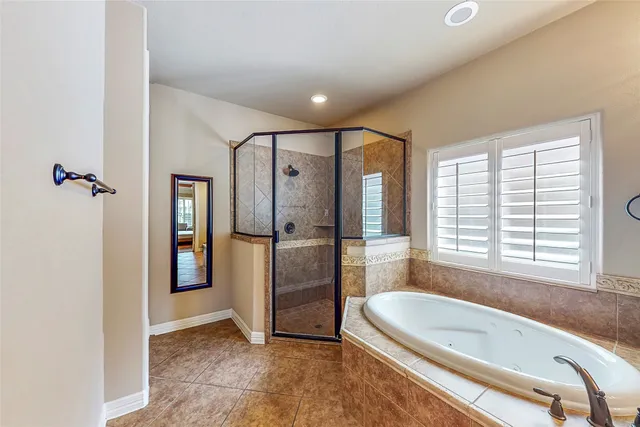 a spacious bathroom with a tub a sink and a shower