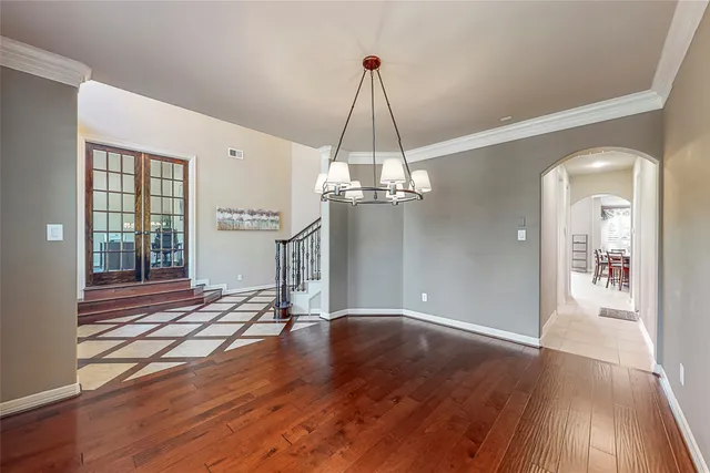 a view of a room with wooden floor staircase and a kitchen