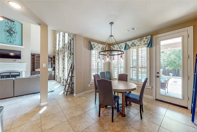 a view of a dining room with furniture large windows and a chandelier