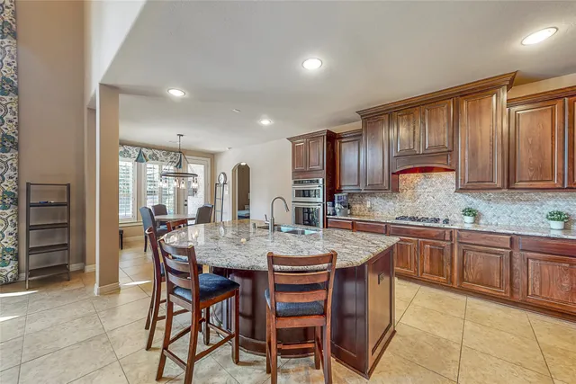 a kitchen with granite countertop cabinets and chairs