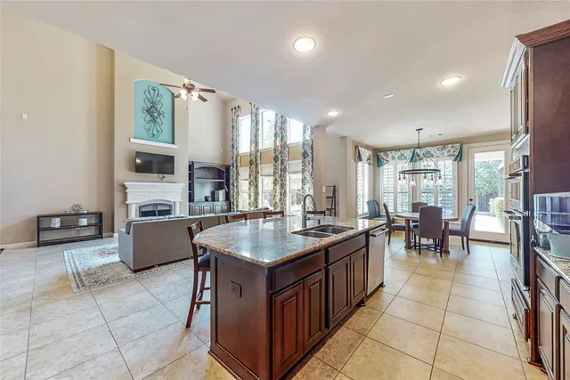 a kitchen with stainless steel appliances granite countertop a stove a sink a oven and a dining table
