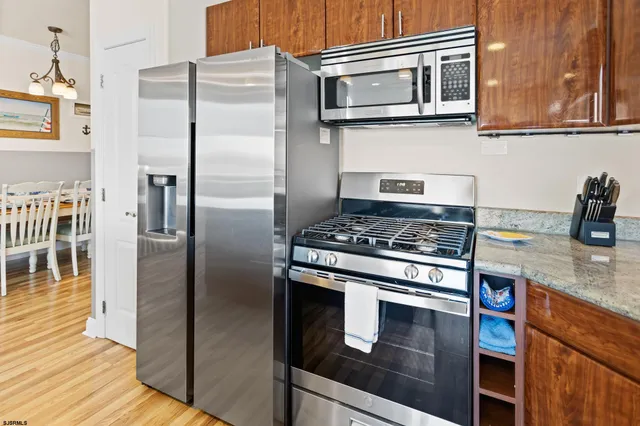 a kitchen with stainless steel appliances granite countertop a sink dishwasher a stove and a refrigerator