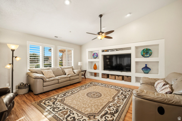 1985 West Rivers Edge Lane St. George, UT 84770 - Photo 15 of 42 Living room featuring built in features, light wood-style flooring, vaulted ceiling, and a ceiling fan