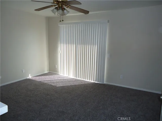 a view of a livingroom with a ceiling fan and window