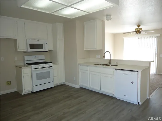 a kitchen with sink a microwave and cabinets
