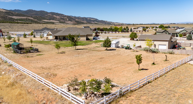 3311 West Allard Summit, UT 84772 - Photo 9 of 97 Expansive property featuring a ranch-style residence with a covered patio, a separate outbuilding, a white picket fence, a small fenced enclosure, and surrounding open terrain with distant mountains
