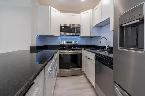 a kitchen with stainless steel appliances granite countertop a stove and a sink